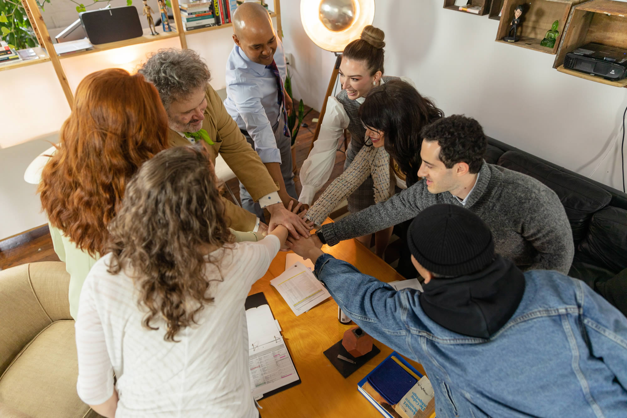 Diverse workplace team joining hands during a collaborative session