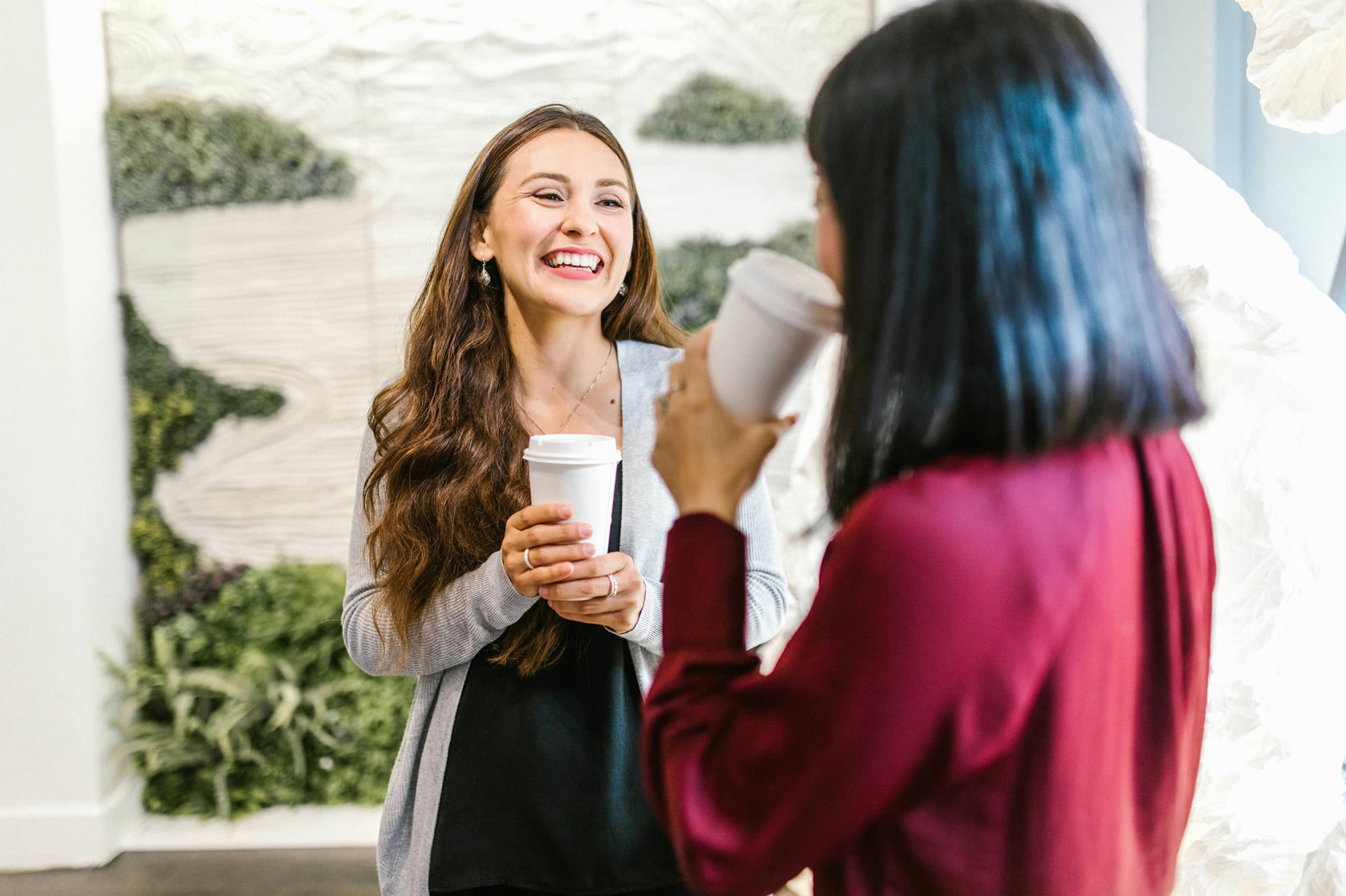 Two professional women connecting over coffee in the workplace