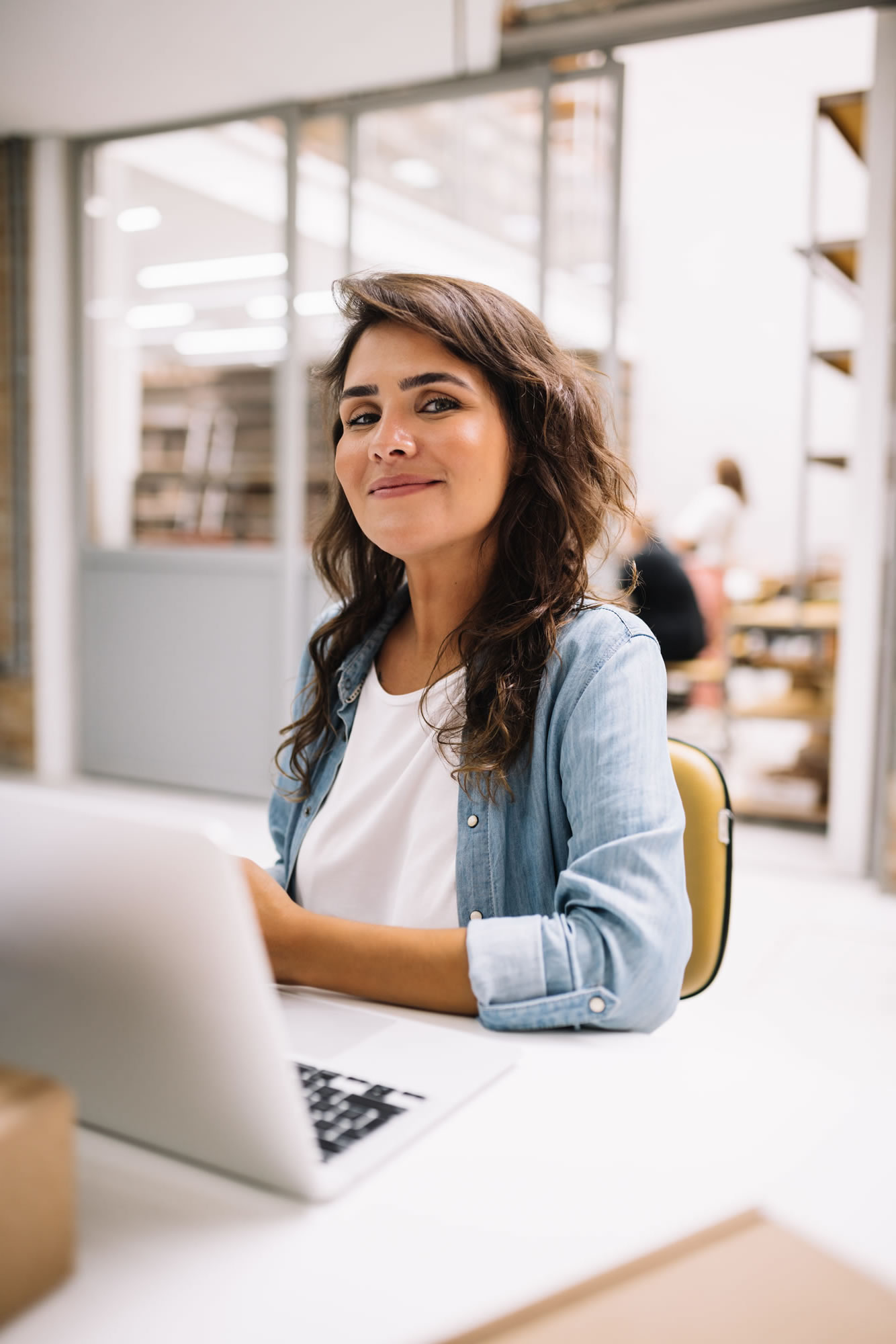 Woman working confidently at a laptop in a modern workplace