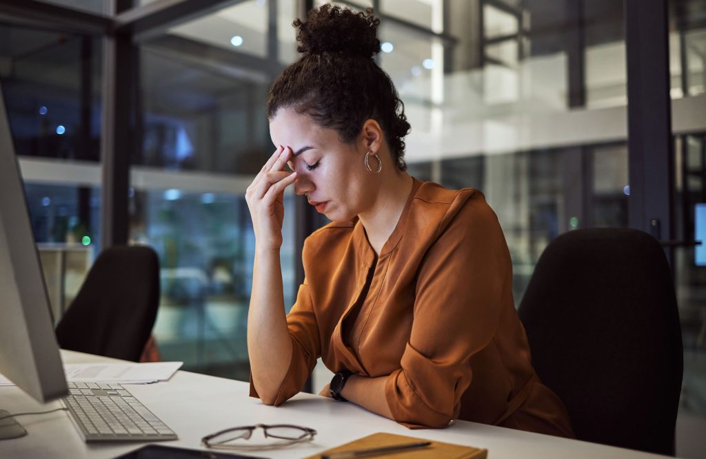 Woman experiencing stress and exhaustion while working at her desk