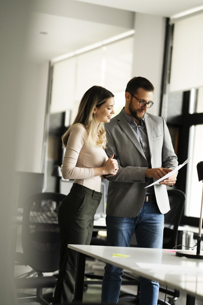 Female and male colleagues reviewing a document in a modern office