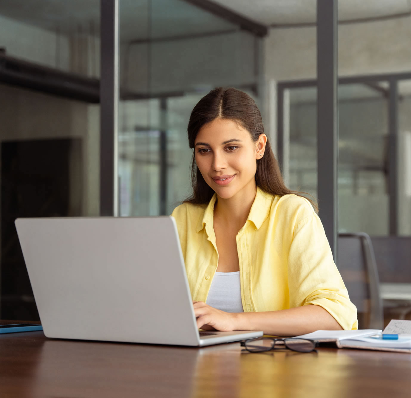 Woman working confidently at a laptop in a modern office