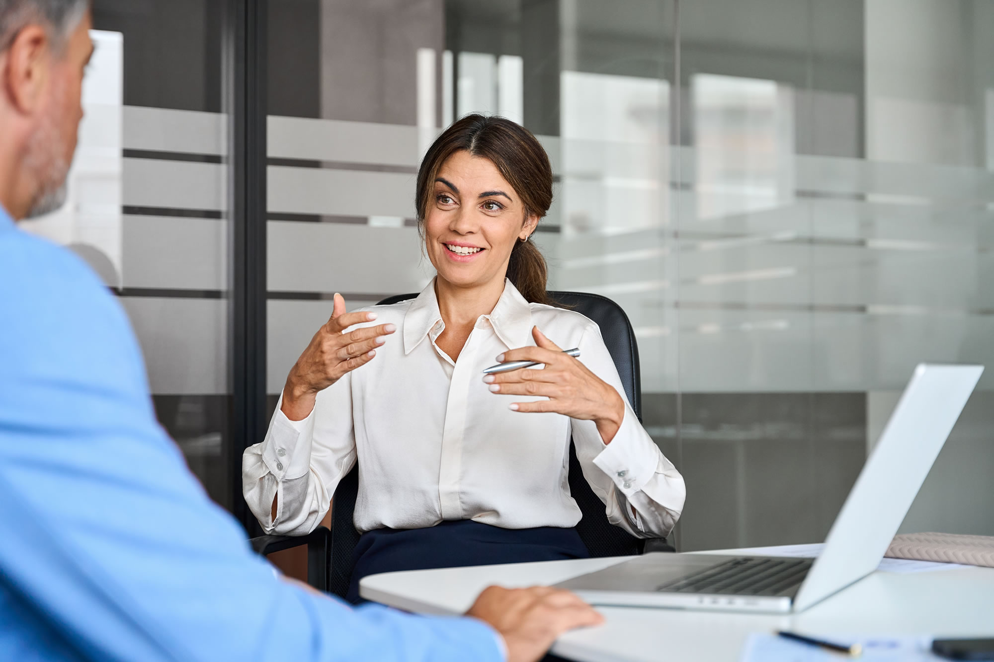 Woman executive speaking with a male colleague during an office meeting